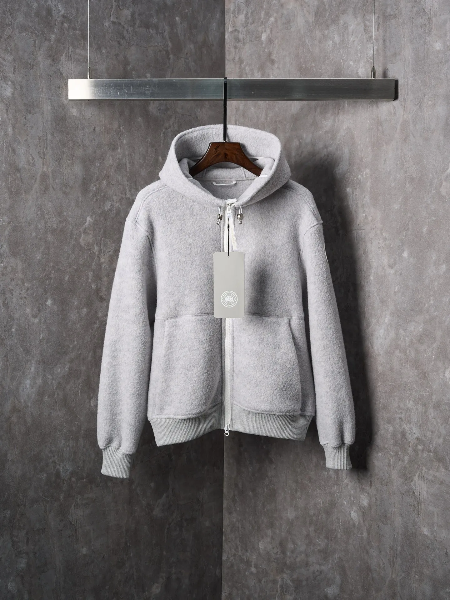 P780 Actual hanging auction] CANADA GOOSE/Canada Goose Chilliwack white label wool fleece hooded jacket [Ready stock] S M L XL Fabric selection: Wool fleece fabric made of wool as the main body and a very small amount of spandex and polyester fiber blended. Wool is a core natural ingredient that provides unparalleled temperature regulation, antibacterial and anti-odor properties and a skin-friendly feel. The feeding of a small amount of spandex gives the fabric a certain degree of four-way elasticity, making it non-restrictive during daily activities. As the basis of fleece's structure, polyester fiber enhances the fabric's durability, wrinkle resistance and quick-drying properties. It contributes to the loft of the fleece and provides functions such as trapping air.  Detail 1: The sleeves and hem are closed with 2×2 ribbing. Its strong elasticity can closely fit wrists and waists of different thicknesses, forming an effective 'seal' to prevent cold wind from blowing back. It can still maintain its original shape after repeated stretching and use, and is not easy to loose and deform. And the ribbed cuffs can convey a sense of design and enhance the visual beauty.  Detail 2: The combination of hood design and elastic buckle improves warmth and windproof performance when wearing.